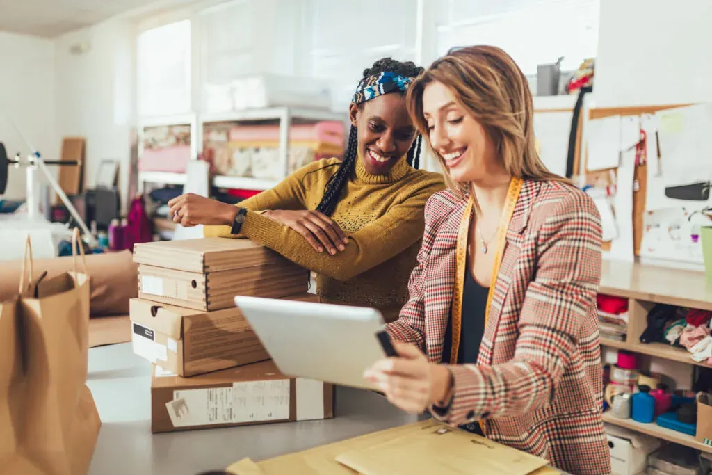 Mujeres trabajadoras en su tienda. Aceptan nuevos pedidos online y empaquetan la mercancía para el cliente.